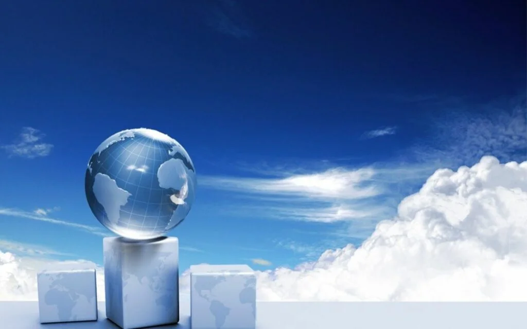 Hình nền PowerPoint đẹp với quả địa cầu thủy tinh trên khối lập phương trắng giữa bầu trời xanh và mây trắng
