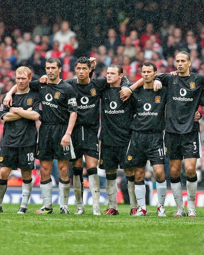 Ảnh bóng đá sáu cầu thủ Manchester United đứng sát cánh trên sân dưới trời mưa