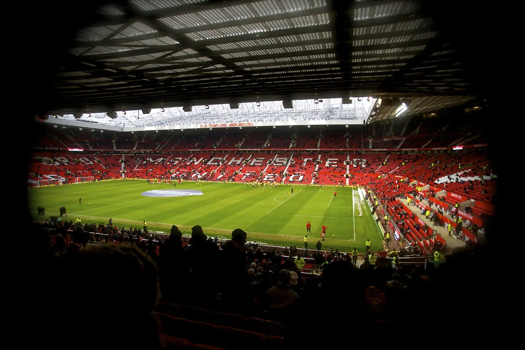 Ảnh bóng đá nhìn toàn cảnh sân vận động Old Trafford với sân cỏ xanh và khán đài đỏ
