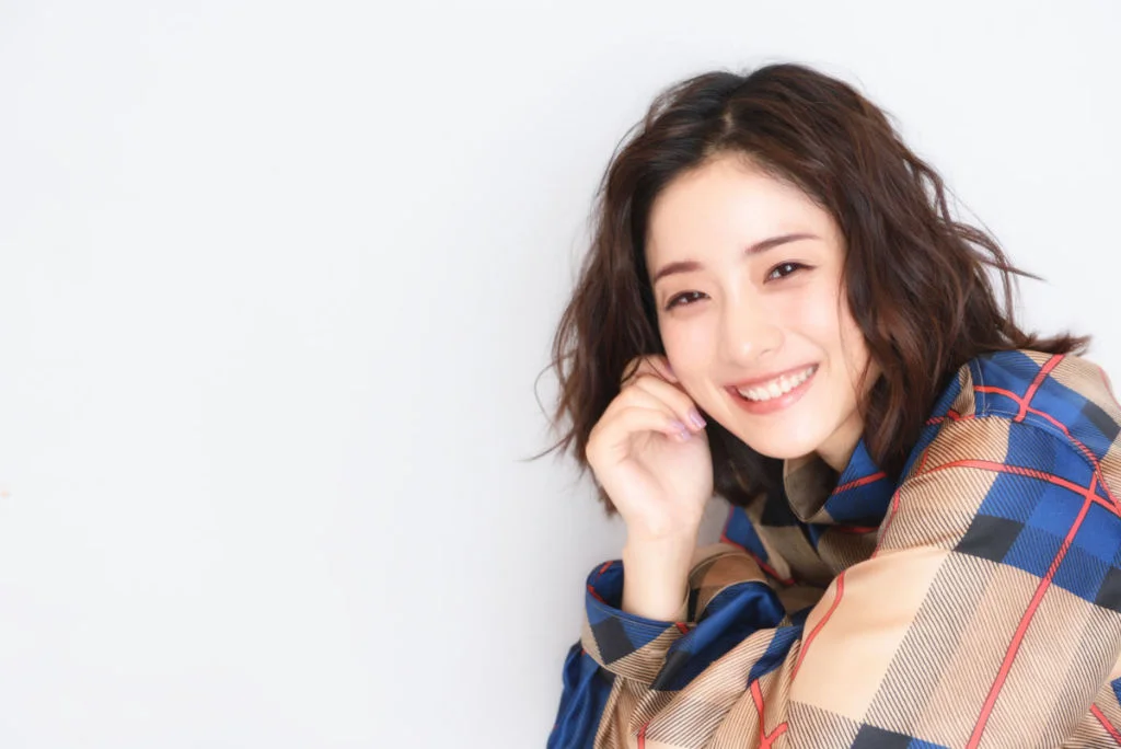Hình ảnh cute nữ với cô gái trẻ mỉm cười trong áo khoác caro nhiều màu trên nền trắng