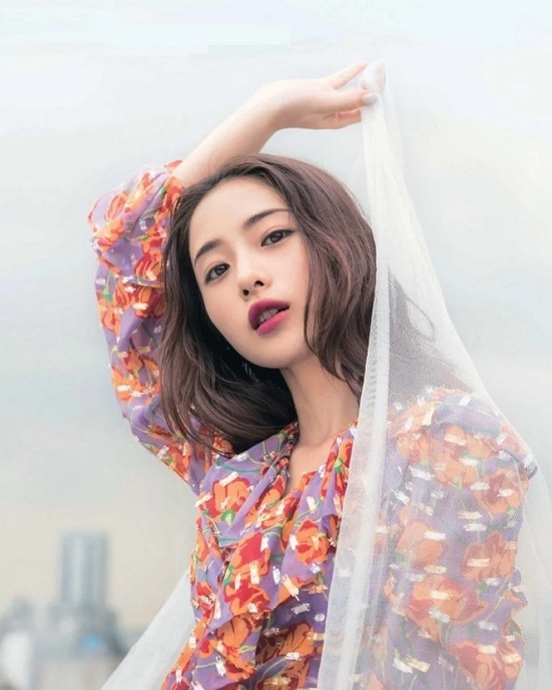 Hình ảnh cute nữ mặc váy hoa nhiều màu và tạo dáng duyên dáng bên lớp voan trắng mộng mơ